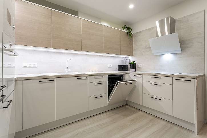 Kuchyňská linka a sestavy úložného nábytku jsou v jemném odstínu bílé