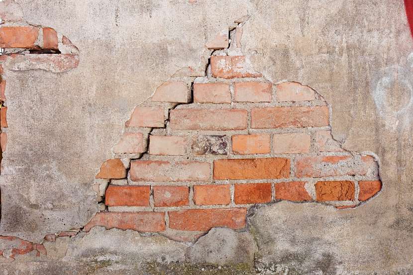 Vlhkost z půdy viditelně poškozuje zdivo domu, omítka časem úplně opadá