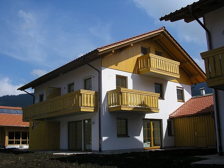Balkony na domě ladí i s obložením štítu, dělicí stěnou, s typem oken a garážovým přístavkem