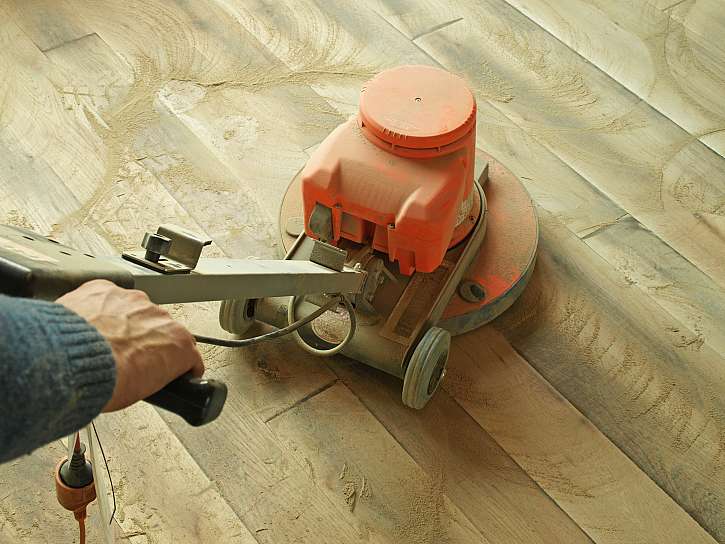 Broušení dřevěné podlahy velkou bruskou