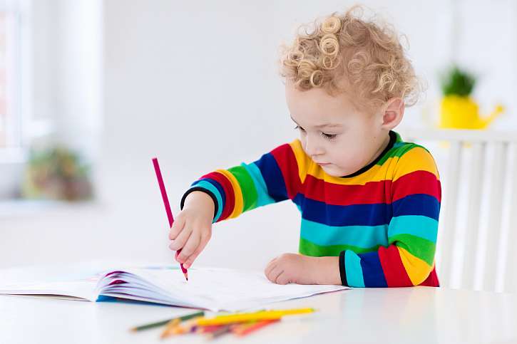 Chlapec kreslí pastelkou