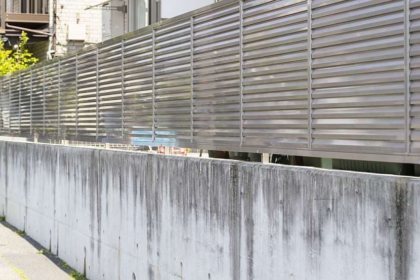 Betonový plot s kovovým vrškem je fádní a nehezká záležitost