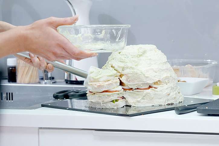 Poskládaný korpus dortu pomažte některou z pomazánek, aby na něm sýr lépe držel