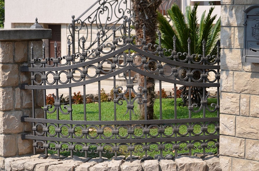 Kovaný plot se sloupky z umělého betonu je vysoce estetické řešení