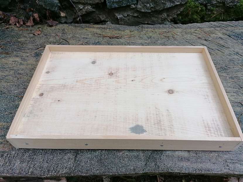 Ze dřeva zhotovená základní deska s přibitými lištami