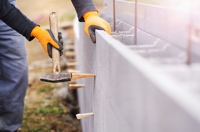 Dělník na stavbě staví plot ze ztraceného bednění