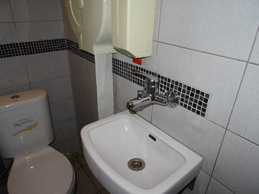 Antikutil - trubky v koupelně vedou pod mozaikou