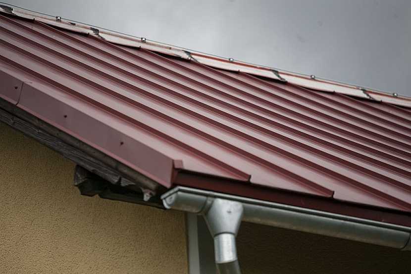 Špatný příklad kombinace kvalitní krytiny s levným plechem na hřebeni střechy. Životnost střechy se tímto krokem snižuje.