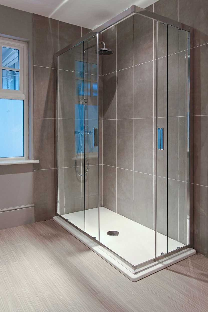 Luxusní prostorný sprchový kout s nízkou, profilovanou vaničkou a skleněnými posuvnými dveřmi zve k použití