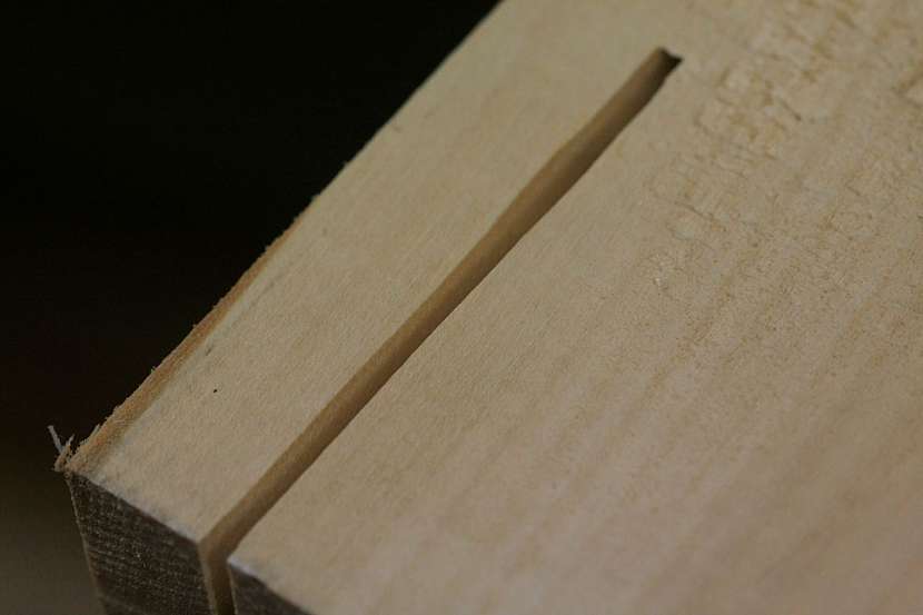 Makrosnímek řezu kotoučové pily – maflíku. Na této straně kotouč vstupuje do dřeva, proto je řez bez otřepů
