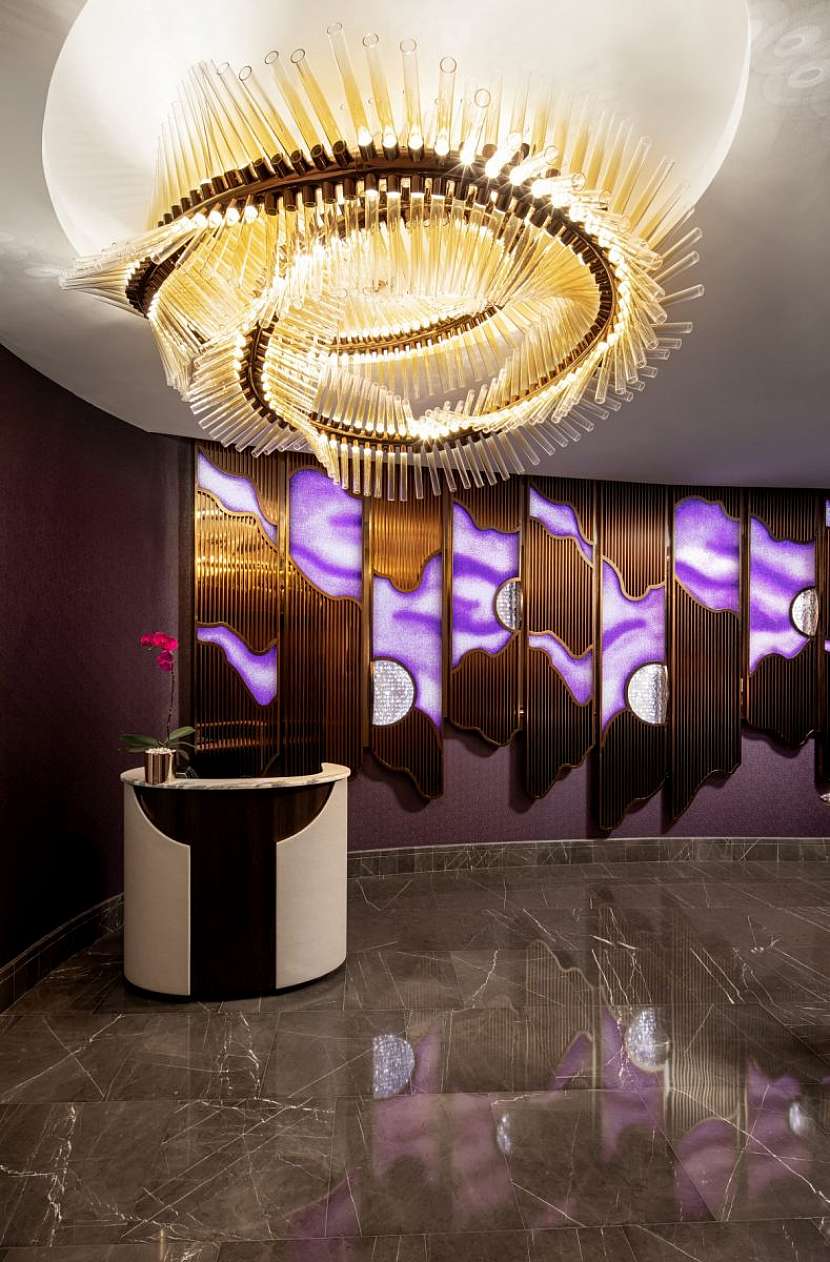 Více než sedm metrů vysoká zářivě fialová křišťálová stardustová zeď vítá hosty baru a restaurace Ossiano.
