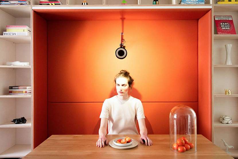 Dominantním prvkem obytného prostoru je oranžová čalouněná lavice u jídelního stolu.