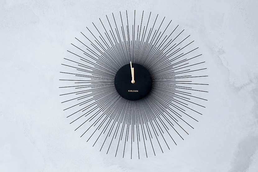 Na zdi se šedou stěrkou upoutají designové hodiny značky Karlsson.