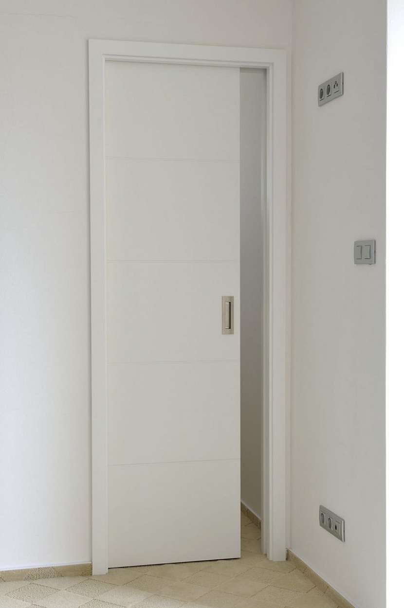 Klasika v podobě bílých dveří a zárubní ve variantě posuvu do stěny.