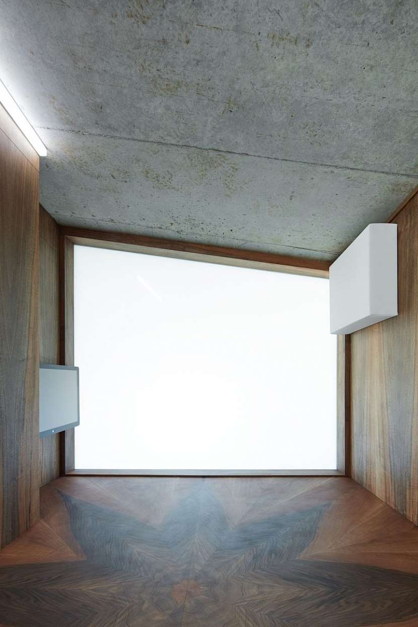 Vedle zářivě bílé a pohledového betonu se v domě objevuje i dřevo s výraznou kresbou.