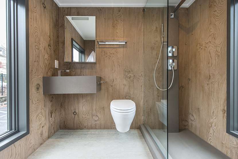 Sprchový kout odděluje do zbytku koupelny pouze skleněná stěna.