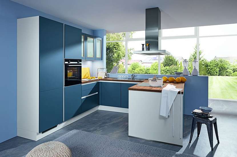 K moderní kuchyni Areka z prémiové třídy Livanza v barvě Ocean Blue se dokonale hodí stěrková podlaha ve vzhledu betonu a pracovní deska z masivu.