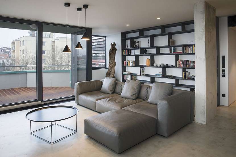 Dominantou obývacího pokoje je kožená pohovka Mex Cube od značky Cassina. Doplňuje ji designový konferenční stolek Fat Fat od B&amp;B Italia.