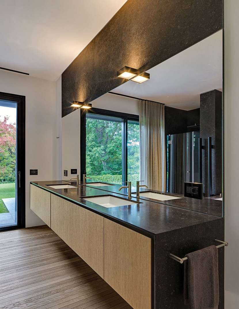 Koupelně dominují stejné materiály jako celému domu – dřevo a žula.