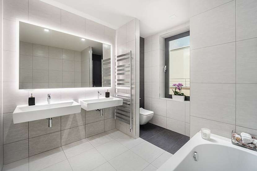 Prostorná koupelna zajišťuje dokonalý komfort s dvojumyvadlem, sprchovým koutem, vanou a velkým oknem.