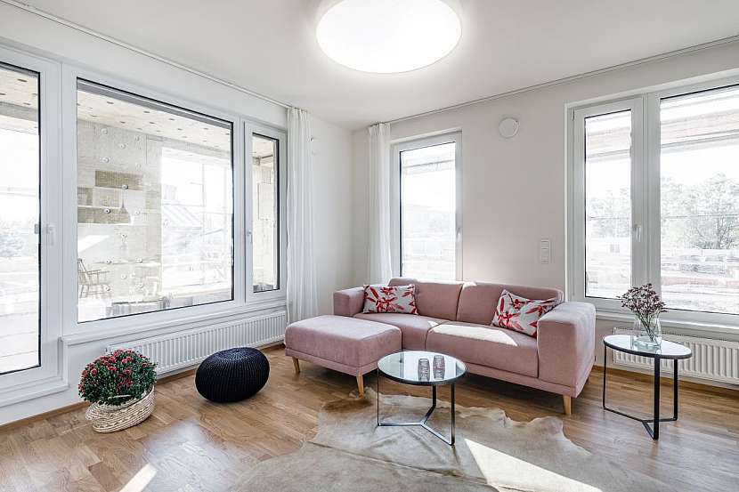 Starorůžová sedací souprava s přírodní kůží na podlaze oživuje obývací pokoj.