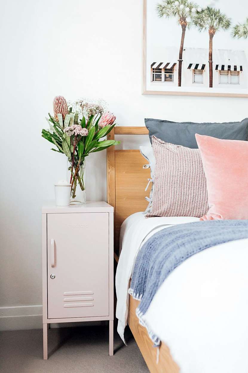 Romantická ložnice s plechovou skříňkou přetřenou na růžovo.