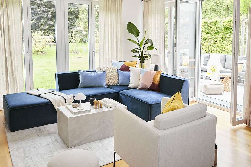 Obývací pokoj je zalitý sluncem a velká okna ho spojují se zahradou.