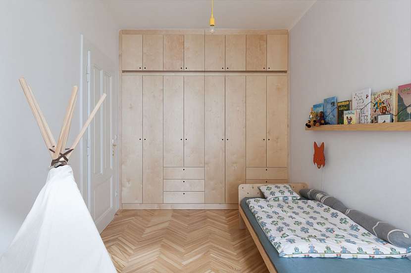 I dětský pokoj pro předškoláka je navržen na míru a nábytek z překližky pouze minimalistickým dekorováním odlišen oproti ostatnímu nábytku v bytě. .