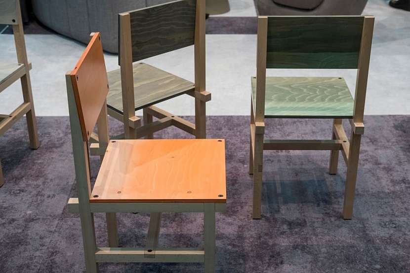 Jednobarevný koberec, efekt dvou odstínů tvoří různě položený vlas koberce. Na něm židle Röhsska.