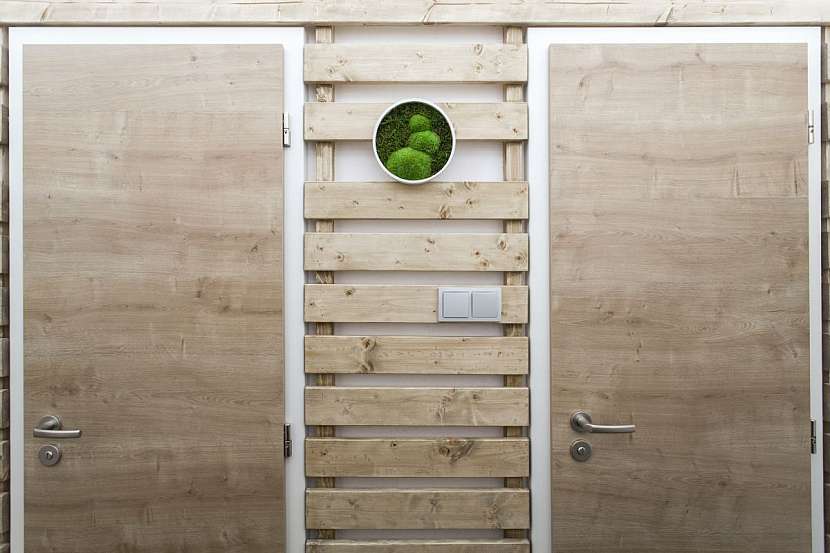 Ekologický ráz bytu určují dřevěné dveře a obklady stěn z prken.
