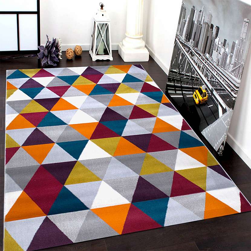 Barevný kusový koberec s geometrickými vzory.