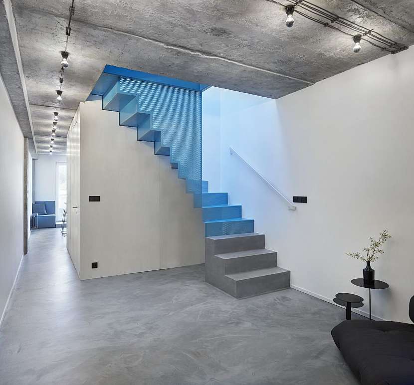 Dominantou a vlastně i hlavní tepnou a srdcem domu se stalo ocelové zavěšené schodiště potažené výrazným modrým lakem.