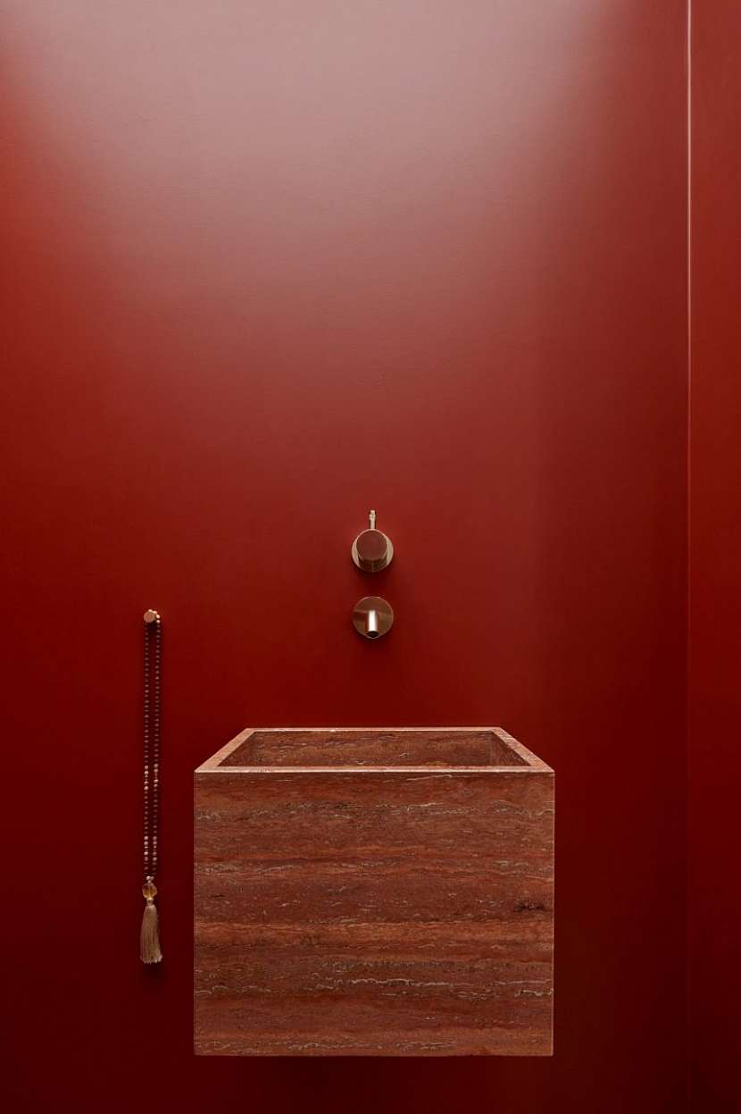 Za bílými dveřmi vás překvapí sytě rudá toaleta.