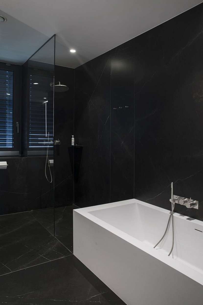 Koupelny jsou obložené tmavě šedými velkoformátovými keramickými obklady. Vybavené jsou koupelnovými prvky značky Boffi.