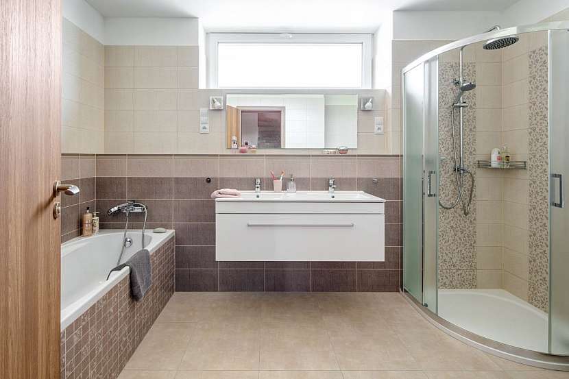 V koupelně v přízemí jsou obdélníková vana, sprchový kout, dvojumyvadlo a navíc také toaleta.