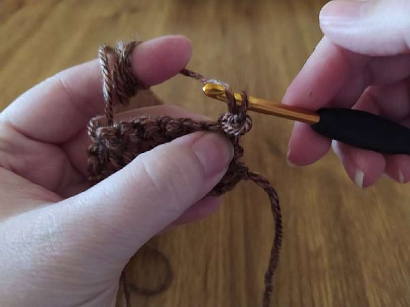 Druhý typ oka, který se v různých kombinacích střídá s jednoduchým stehem je tzv. polosloupek nebo half double crochet stitch. I ten uháčkujete velmi snadno. V prvním kroku na háček seshora nahoďte vlnu