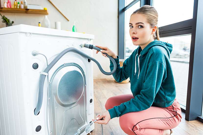 Žena kontrolující pračku