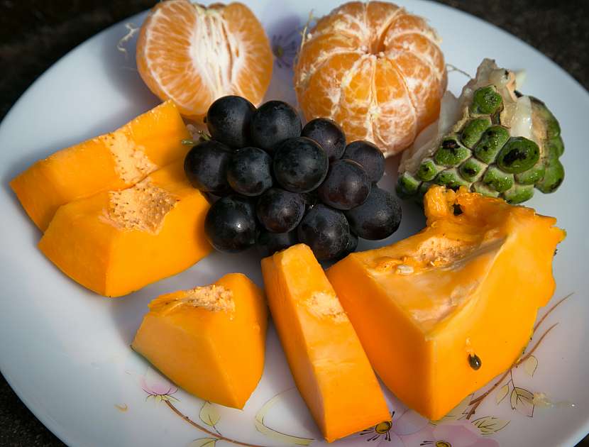 Tropické ovoce na talíři představuje zdravou snídani nebo svačinu