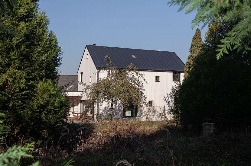 Rodinný dům mezi paneláky má dvě části spojené chodníčkem