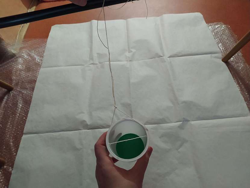 Kelímek si připravte do pozice, aby se pak pěkně houpal nebo točil a ve chvíli, kdy ho budete chtít pustit, odlepte ze dna i lepicí pásku
