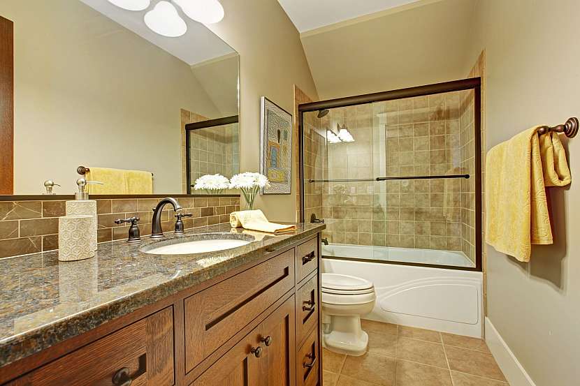 Interiér koupelny s vanou se skleněnou zástěnou