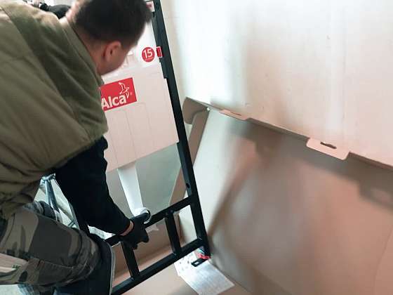 Technici z Alcaplastu namontovali do WC místnosti WC panel s tlačítkem
