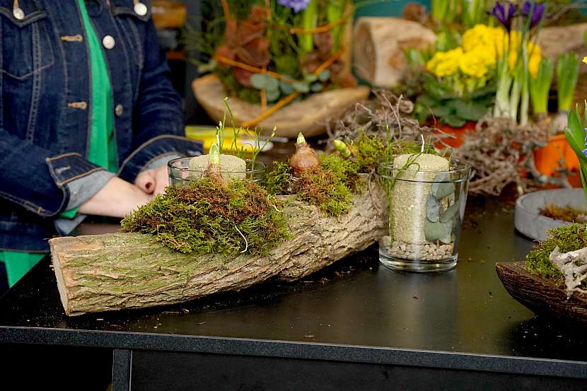 Aranžování jarních květin na přírodní materiály společně se svícny