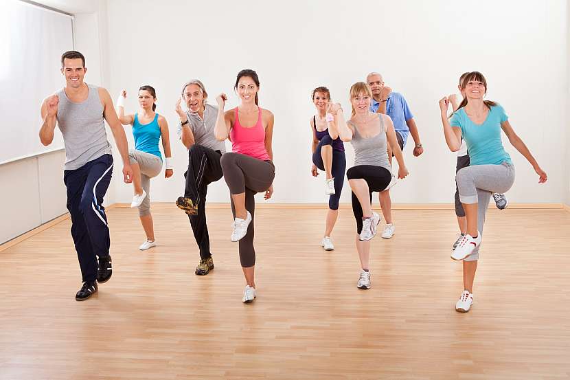 Muži a ženy cvičí aerobik