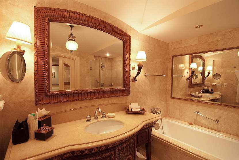Koupelna se zrcadlem nad umyvadlem a nad vanou
