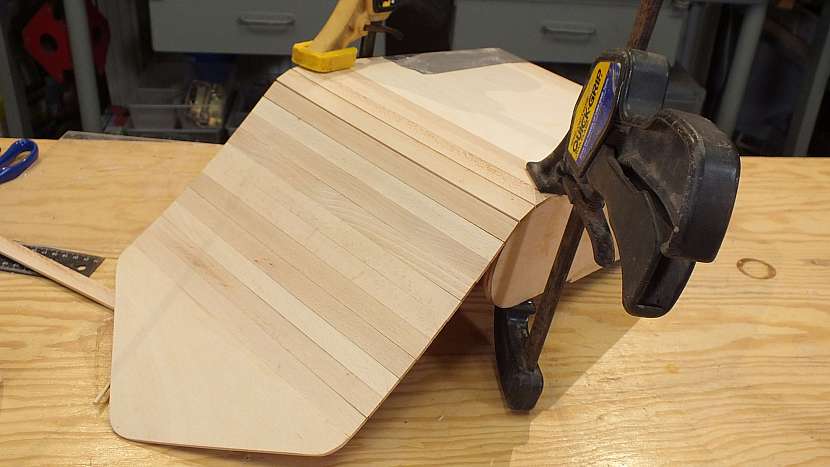 Jak se dělá dřevěný batoh: hotový díl přilepíme k přesahu plátna, stejně jako lišty roletky