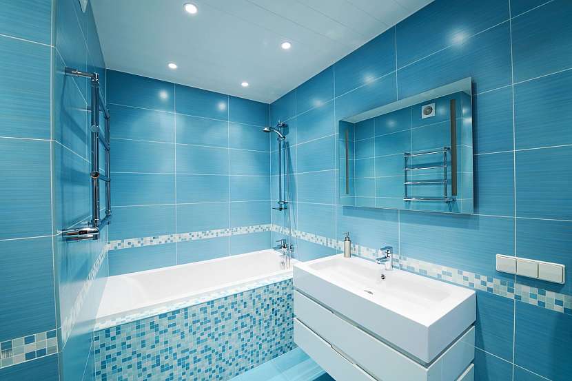 Modrá koupelna malých rozměrů s bezrámovým zrcadlem