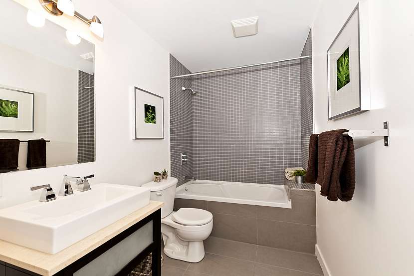 Moderní koupelna se zrcadlem, umyvadlem, toaletou a vanou