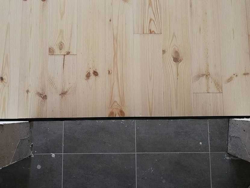 Detail dilatační spáry - přechod mezi dřevěnou podlahou a dlažbou. Spáru překryje dřevěná lišta.