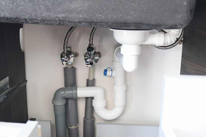 Vodovodní instalace se mohou vést např. před omítkou (zde pod kuchyňskou linkou)